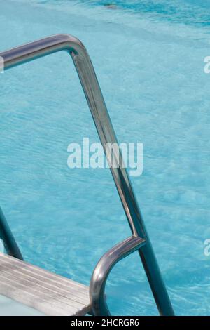 Detail of the steps and chrome hand rail of the outside swimming pool on the Cunard cruise line Queen Elizabeth Stock Photo