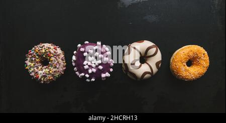 various baked donuts in a row, sweet food Stock Photo