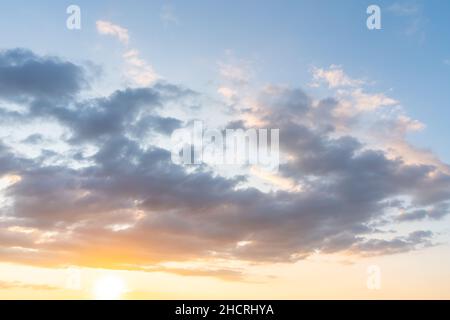 sunset clouds with sun setting down Stock Photo