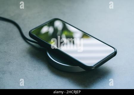 smartphone wireless charging on induction charger. Wireless charger Stock Photo