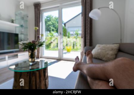blur image of modern living room at home with man relaxing at the couch Stock Photo