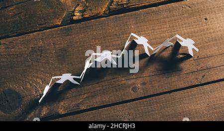 people cut out of paper on wooden table background Stock Photo