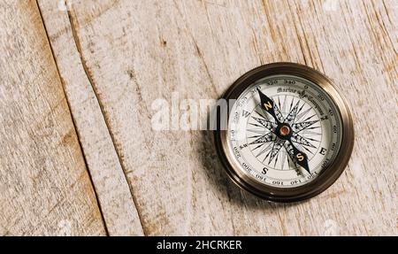old compass on wood background concept for direction, travel, guidance or assistance Stock Photo