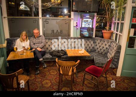 Two people sit at their table inside the Queens pub in Swansea on