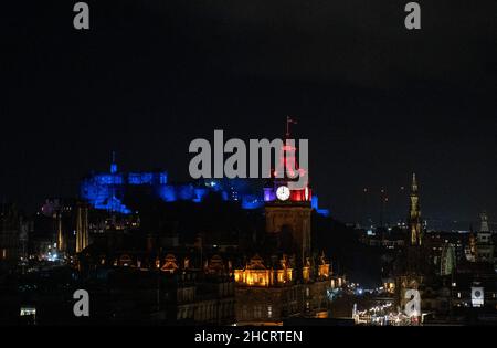 Edinburgh Castle and the Balmoral Clock at midnight at the bells on New Year's Eve Edinburgh as the limit on the number of people who can take part in events has seen New Year's Eve street parties cancelled, including the one planned for Edinburgh. Picture date: Friday December 31, 2021. Stock Photo