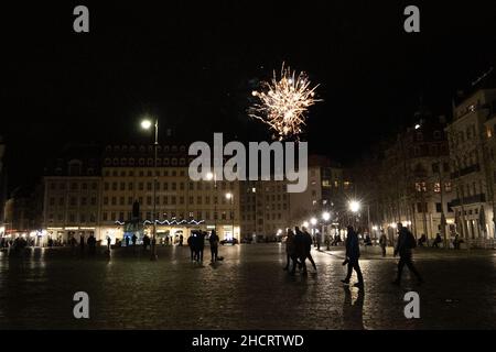 Dresden, Germany. 01st Jan, 2022. A New Year's Eve rocket goes up in the air above the houses of the historic old town of Dresden and explodes. In public places, the ignition of pyrotechnics is prohibited, so they are launched in side streets. Credit: Daniel Schäfer/dpa-Zentralbild/dpa/Alamy Live News Stock Photo