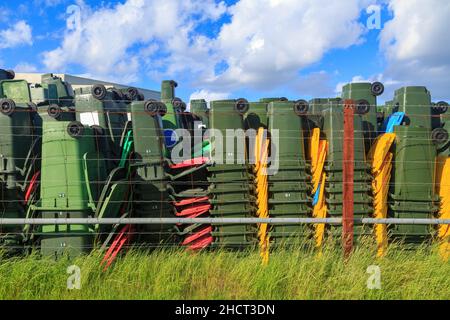 Stacks of plastic rubbish and recycling wheelie bins, sitting unused in a storage yard Stock Photo