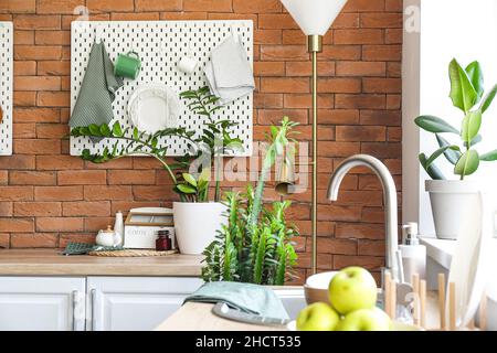 Peg board with kitchenware hanging on brick wall Stock Photo