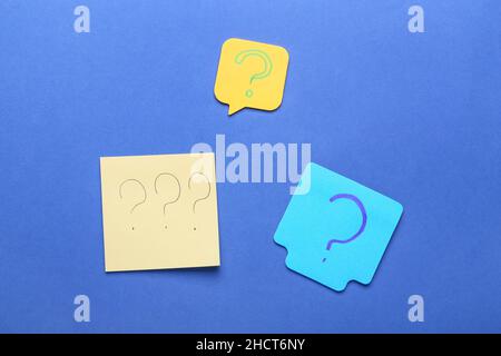 Sticky notes with question marks on blue background Stock Photo