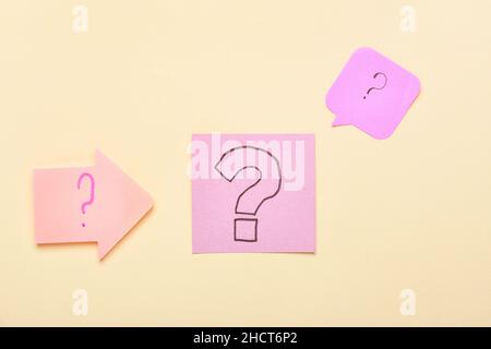 Pink sticky notes with question marks on beige background Stock Photo