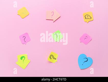 Sticky notes with question marks on pink background Stock Photo