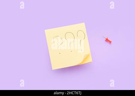 Sticky notes with question marks and pin on lilac background Stock Photo