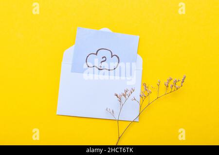 Sticky note with question mark, envelope and flowers on yellow background Stock Photo