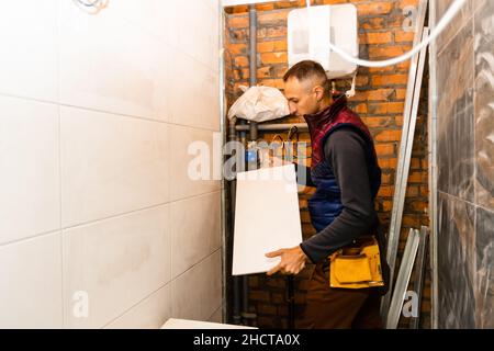 industrial tiler builder worker installing floor tile at repair renovation work. Stock Photo