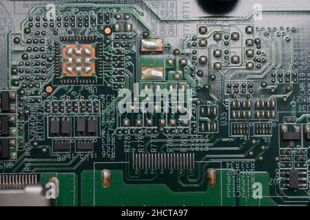 Closeup of computer board with various solder joints capacitors transistors and chips Stock Photo