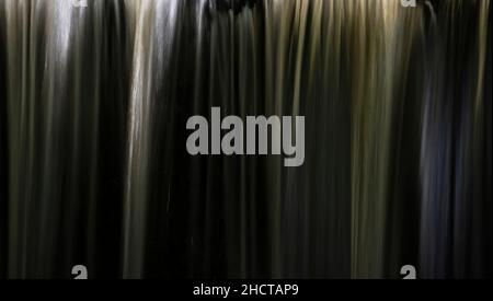 Stunning beautiful Autumn landscape image of Nant Mill waterfall in Wales with glowing sunlight through the flowing water Stock Photo