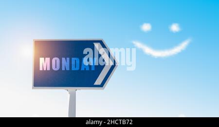 Monday sign against blue sky with happy clouds face. Stock Photo