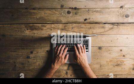 Overhead View Of Businessman Working At Computer In Office, with copyspace for your individual text. Stock Photo