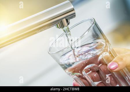 filling glass with drinkable water Stock Photo