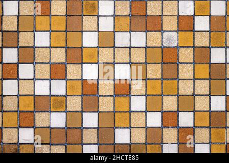 Background from a wall of brown, beige and ocre mosaic tiles Stock Photo