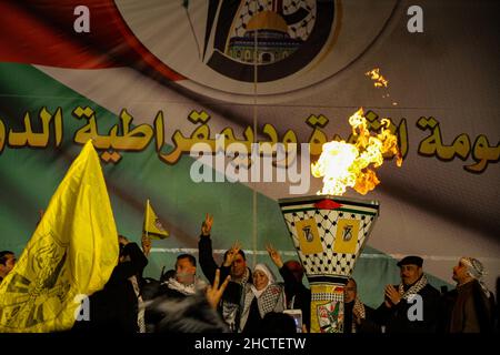 Gaza City, Gaza Strip, Palestine. 31st Dec, 2021. Gaza, Palestine. 31 December 2021. Palestinians gather at Palestine Square in Gaza City during a rally to mark the 57th anniversary of the establishment of the Palestinian National Liberation Movement of Fatah. Participants waved Fatah yellow flags and lighted a torch while shouting slogans in support of the Palestinians' struggle for independence and against the Israeli occupation. Similar rallies and celebrations took place in several West Bank towns and cities (Credit Image: © Ahmad Hasaballah/IMAGESLIVE via ZUMA Press Wire) Credit: ZUMA Pre Stock Photo