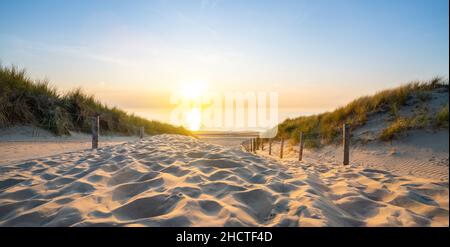Wooden path at Baltic sea over sand dunes with ocean view, sunset summer evening Stock Photo