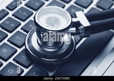 Silver stethoscope lying down on an laptop Stock Photo