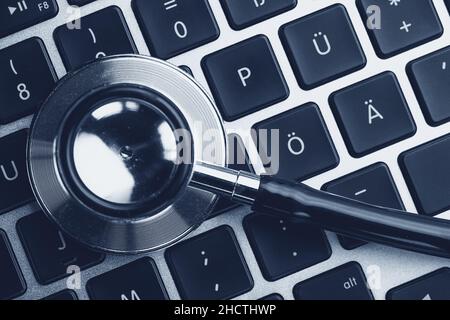 Stethoscope lying on laptop keyboard. Laptop infected by virus concept image Stock Photo