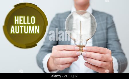 Sign displaying Hello Autumn. Business idea that weather begins to get colder and trees shed their leaves Lady in outfit holding lamp with two hands Stock Photo