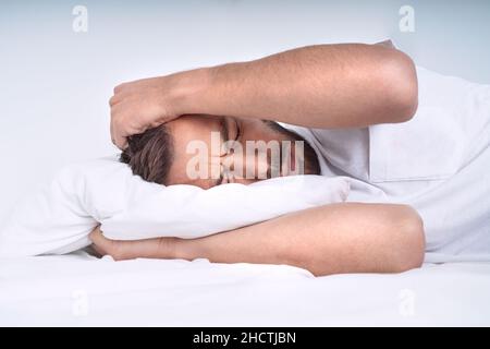 Young man with emotional stress feeling pain and suffering from tension headache, migraine or depression Stock Photo
