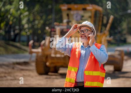 Surveyor builder Engineer technician  Business Team discuss plan at new construction site. Road construction machinery on the construction of highway. Stock Photo