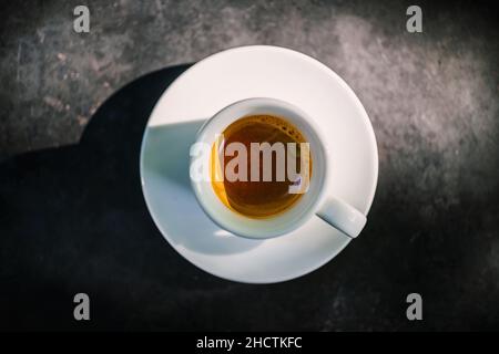 white cup of espresso coffee on dark background