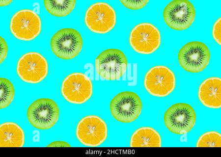Fruits slices pattern, top view of kiwi and lemon slices isolated on blue background. Stock Photo