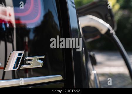 BMW i3s Electric in parking slot in centre of city by charging station city. BMW i3 is a five-door urban electric car developed by the German manufact Stock Photo