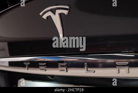 Tesla Logo on a black car. Tesla Motors, Inc. is an American automotive and energy storage company. Stock Photo