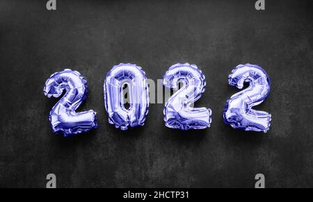 Inflatable numbers New Year 2022 Very Peri color on black background. Copy space. Holiday trends and party concept