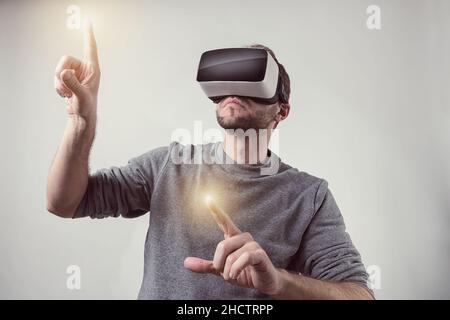 Bearded man wearing Virtual Reality VR Headset gaming goggles Stock Photo
