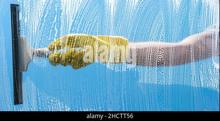 Cleaning concept - Young Man washing window Stock Photo