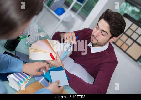 interior designer showing colour wheel to client in his studio Stock Photo