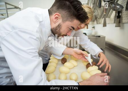 portrait of people making chocolate eggs Stock Photo