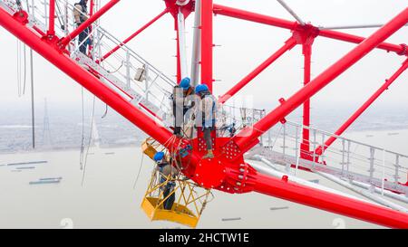 WUXI, CHINA - JANUARY 1, 2022 - Construction workers assemble the world's tallest power transmission tower at a height of 100 meters at the constructi Stock Photo