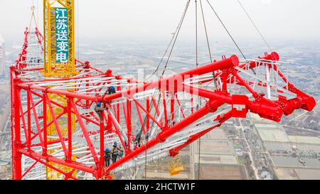 WUXI, CHINA - JANUARY 1, 2022 - Construction workers assemble the world's tallest power transmission tower at a height of 100 meters at the constructi Stock Photo