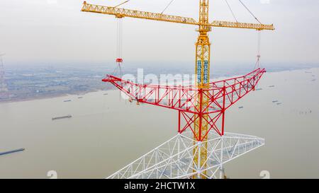 WUXI, CHINA - JANUARY 1, 2022 - Construction workers assemble the world's tallest power transmission tower at a height of 100 meters at the constructi Stock Photo