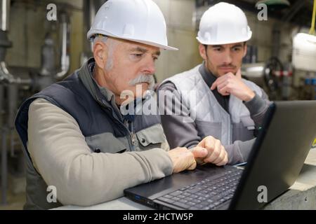 two engineers working on a laptop Stock Photo