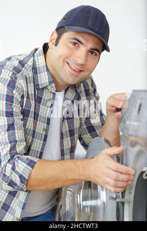 a man is fixing a washing machine Stock Photo