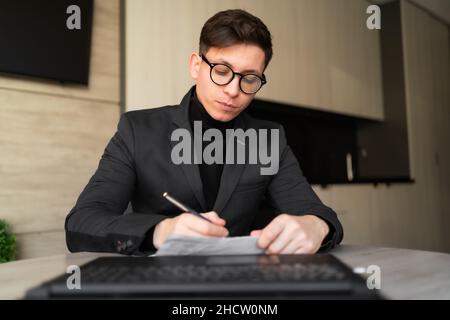 Caucasian male manager with glasses places an order, looking at the camera, webcam view, male vacancy candidate makes a video call, remote interview Stock Photo