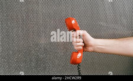 hand holding a red telephone receiver, office concept image Stock Photo