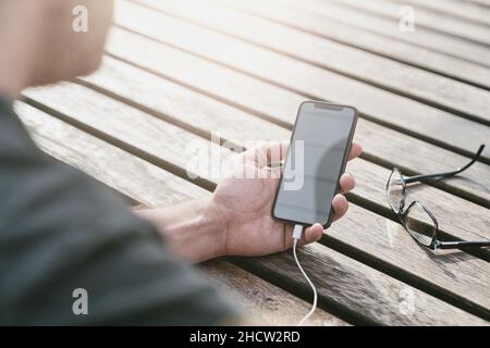 man using a smart phone in his outdoor office Stock Photo