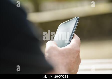 man using his Mobile Phone in the street Stock Photo