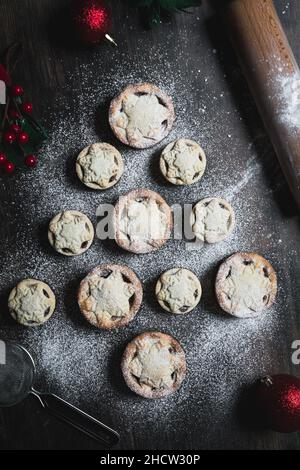A home baking concept of traditional Christmas mince pies arranged in the shape of a Christmas Tree and covered in icing sugar Stock Photo